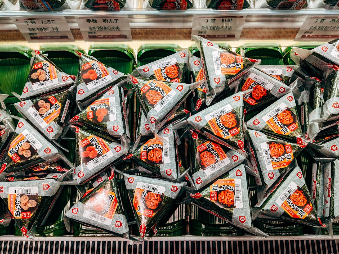 A display of packaged Japanese onigiri rice balls on a store shelf, showcasing variety and convenience.